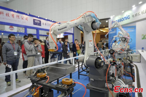 Visitors look intelligent robot demonstrating operation at the 11th China (Tianjin) International Equipment and Manufacturing Expo in Tianjin, March 12, 2015. The expo, covers an area of 80,000 square meters, is the largest robot show in China. China is now the world's largest industrial robot market with over 30 robot factories under construction, Xinhua reported in 2014. (Photo: China News Service/Tong Yu) Visitors look intelligent robot demonstrating operation at the 11th China (Tianjin) International Equipment and Manufacturing Expo in Tianjin, March 12, 2015. The expo, covers an area of 80,000 square meters, is the largest robot show in China. China is now the world's largest industrial robot market with over 30 robot factories under construction, Xinhua reported in 2014. (Photo: China News Service/Tong Yu)
