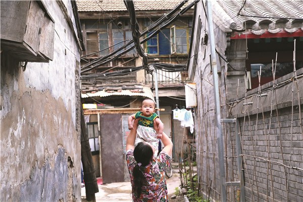 A woman from Anhui province plays with her baby in Beijing's Hongfu Hutong. The hutong is home to many migrant workers from outside the capital and, like many such neighborhoods, has infrastructure challenges. Zou Hong / China Daily A woman from Anhui province plays with her baby in Beijing's Hongfu Hutong. The hutong is home to many migrant workers from outside the capital and, like many such neighborhoods, has infrastructure challenges. Zou Hong / China Daily