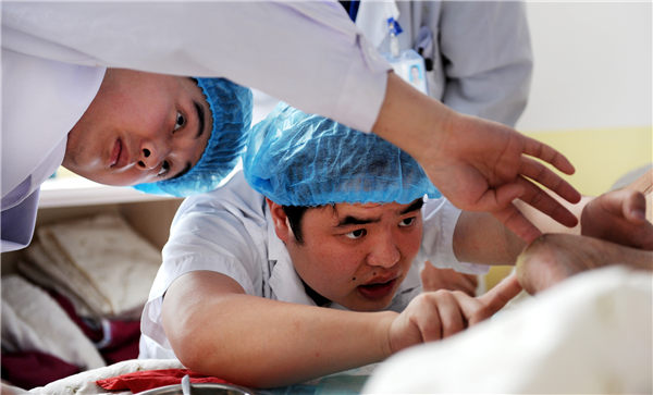 Wu Xufeng (right) treats a patient in the intensive care unit at the Hefei Binhu Hospital, Anhui province. (Photo/China Daily) Wu Xufeng (right) treats a patient in the intensive care unit at the Hefei Binhu Hospital, Anhui province. (Photo/China Daily)