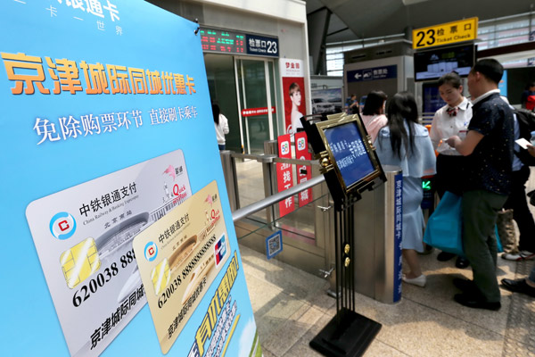 Passengers using commuter passes get aboard a train bound for Tianjin at Beijing South Railway Station on Sunday. (Photo by Wang Zhuangfei / China Daily) Passengers using commuter passes get aboard a train bound for Tianjin at Beijing South Railway Station on Sunday. (Photo by Wang Zhuangfei / China Daily)