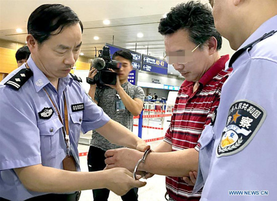 Suspect surnamed Du is handcuffed at Pudong International Airport in Shanghai, east China, June 20, 2017. A suspect has been returned from Canada to China as part of a campaign to capture economic fugitives, Chinese police said Wednesday. (Xinhua/Fan Jun) Suspect surnamed Du is handcuffed at Pudong International Airport in Shanghai, east China, June 20, 2017. A suspect has been returned from Canada to China as part of a campaign to capture economic fugitives, Chinese police said Wednesday. (Xinhua/Fan Jun)