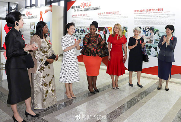 Peng Liyuan, wife of President Xi Jinping, is flanked by a group that includes the wives of leaders of BRICS and other invited countries, as they attend an event to promote HIV/AIDS prevention and control at Xiamen University on Tuesday.(Photo/Xinhua) Peng Liyuan, wife of President Xi Jinping, is flanked by a group that includes the wives of leaders of BRICS and other invited countries, as they attend an event to promote HIV/AIDS prevention and control at Xiamen University on Tuesday.(Photo/Xinhua)