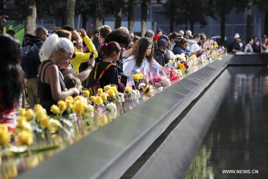 People place flowers on plates on which the names of 9/11 victims were inscribed around the South Pool at the National September 11 Memorial and Museum in New York, the United States, on Sept. 11, 2017. (Xinhua/Wang Ying) People place flowers on plates on which the names of 9/11 victims were inscribed around the South Pool at the National September 11 Memorial and Museum in New York, the United States, on Sept. 11, 2017. (Xinhua/Wang Ying)