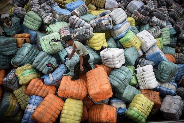 A border guard in Shenzhen, Guangdong province, inpects bundles of waste textiles smuggled into China. (Photo/Xinhua) A border guard in Shenzhen, Guangdong province, inpects bundles of waste textiles smuggled into China. (Photo/Xinhua)