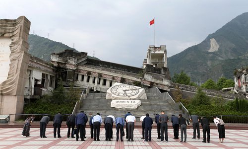 Visitors bow in front of the Xuankou Middle School Memorial in Wenchuan county. (Photo: Cui Meng/GT) Visitors bow in front of the Xuankou Middle School Memorial in Wenchuan county. (Photo: Cui Meng/GT)