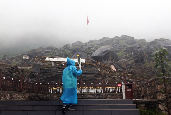 A man lays flowers on Tuesday at the site of Maoba Middle School, which was destroyed in the 2008 earthquake. Many bodies still lie beneath the rubble. (Zou Hong/China Daily) A man lays flowers on Tuesday at the site of Maoba Middle School, which was destroyed in the 2008 earthquake. Many bodies still lie beneath the rubble. (Zou Hong/China Daily)