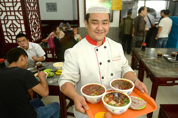 A waiter serves noodles for customers at a noodle restaurant in Lanzhou, Gansu province. (Photo/Xinhua) A waiter serves noodles for customers at a noodle restaurant in Lanzhou, Gansu province. (Photo/Xinhua)
