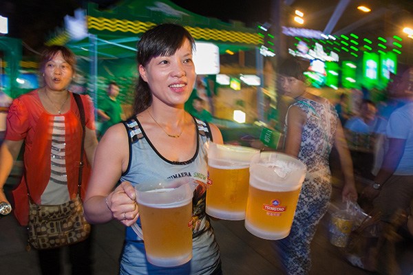 File photo of an attendant serving customers at a Tsingtao beer festival in Jiujiang, Jiangxi province. (Photo/China Daily) File photo of an attendant serving customers at a Tsingtao beer festival in Jiujiang, Jiangxi province. (Photo/China Daily)