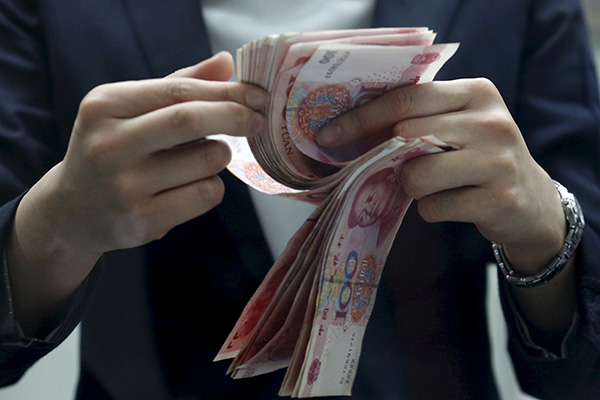 A clerk counts Chinese 100 yuan banknotes at a branch of a foreign bank in Beijing Jan 4, 2016. [(Photo/Agencies) A clerk counts Chinese 100 yuan banknotes at a branch of a foreign bank in Beijing Jan 4, 2016. [(Photo/Agencies)