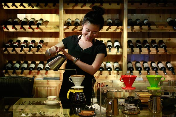 A woman makes coffee in a coffee shop in Pu'er, Yunnan province, a major coffee growing area in China. FENG YONGBIN / CHINA DAILY A woman makes coffee in a coffee shop in Pu'er, Yunnan province, a major coffee growing area in China. FENG YONGBIN / CHINA DAILY
