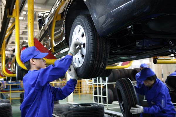 Workers assemble cars at a production line of BYD Co Ltd in Shanghai. BYD is deepening its ties with Correios, Brazil's logistics giant. (HU XI/CHINA DAILY)
