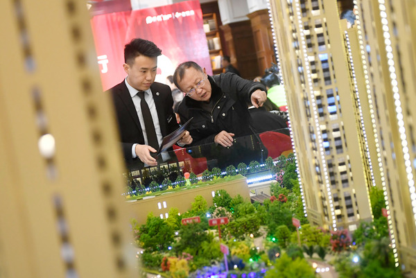 A potential homebuyer checks out a property project in Taiyuan, Shanxi province, on Wednesday. WEI LIANG / CHINA NEWS SERVICES A potential homebuyer checks out a property project in Taiyuan, Shanxi province, on Wednesday. WEI LIANG / CHINA NEWS SERVICES