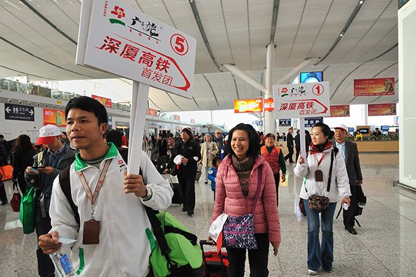 A tour guide from GZL leads a group of tourists to take the first high-speed train connecting Shenzhen in Guangdong province and Xiamen in Fujian province. (Photo/China Daily) A tour guide from GZL leads a group of tourists to take the first high-speed train connecting Shenzhen in Guangdong province and Xiamen in Fujian province. (Photo/China Daily)