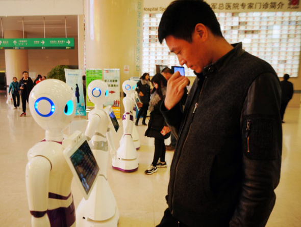 People interact with robots at the 301 Hospital in Beijing. The robots provide basic medical consultation services for people. (Photo by Fan Jiashan/for China Daily) People interact with robots at the 301 Hospital in Beijing. The robots provide basic medical consultation services for people. (Photo by Fan Jiashan/for China Daily)