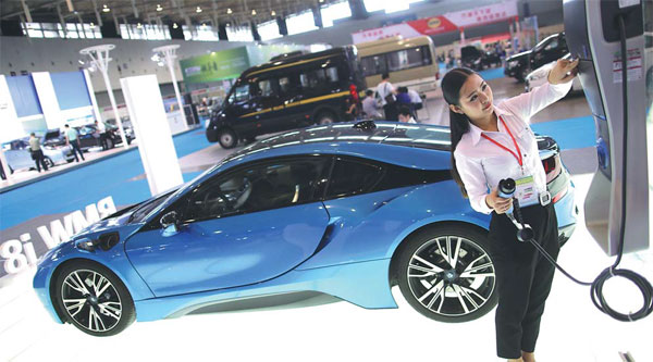 A worker at a new energy vehicle exhibition in Nanjing, Jiangsu province, shows how to charge an electric car. (Photo by Yang Bo/For China Daily) A worker at a new energy vehicle exhibition in Nanjing, Jiangsu province, shows how to charge an electric car. (Photo by Yang Bo/For China Daily)