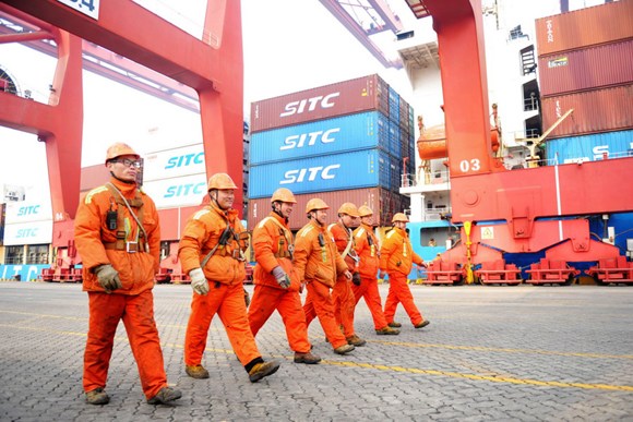 Workers walk past containers at Qingdao Port, Shandong province. (Photo by Yu Fangping/For China Daily) Workers walk past containers at Qingdao Port, Shandong province. (Photo by Yu Fangping/For China Daily)