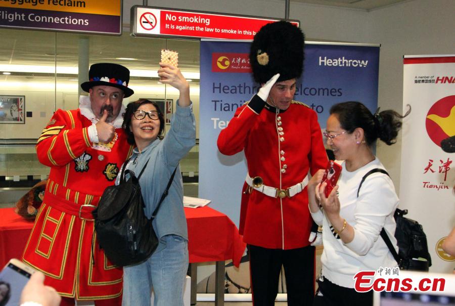 Xiang Xiaowei, the cultural counselor at the Embassy of China in the United Kingdom (2nd R), Zhao Guoqiang, the deputy chairman of Tianjin Airlines and Darren Colderwood (1st L), the development director at Heathrow Airport (2nd L) cut a cake to celebrate the first direct flight from Xi\'an to London. (Photo: China News Service/Zhang Ping)