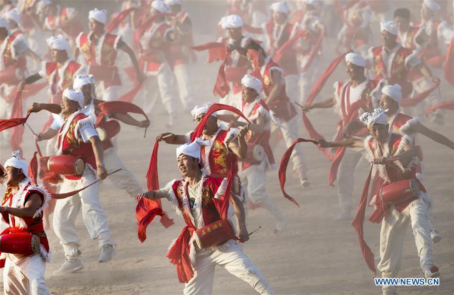 Villagers perform Ansai waist drums for tourists at Fengjiaying Village in Ansai District of Yan\'an City, northwest China\'s Shaanxi Province, May 30, 2018. It is believed that the Ansai Waist Drum dance is a unique, large-scale folk dance with a history of more than 3,000 years. Like a hurricane sweeping across the yellow earth, the dance displays the unsophisticated and wild character of peasant life on the Loess Plateau, revealing its unique artistic charm. (Xinhua/Tao Ming)