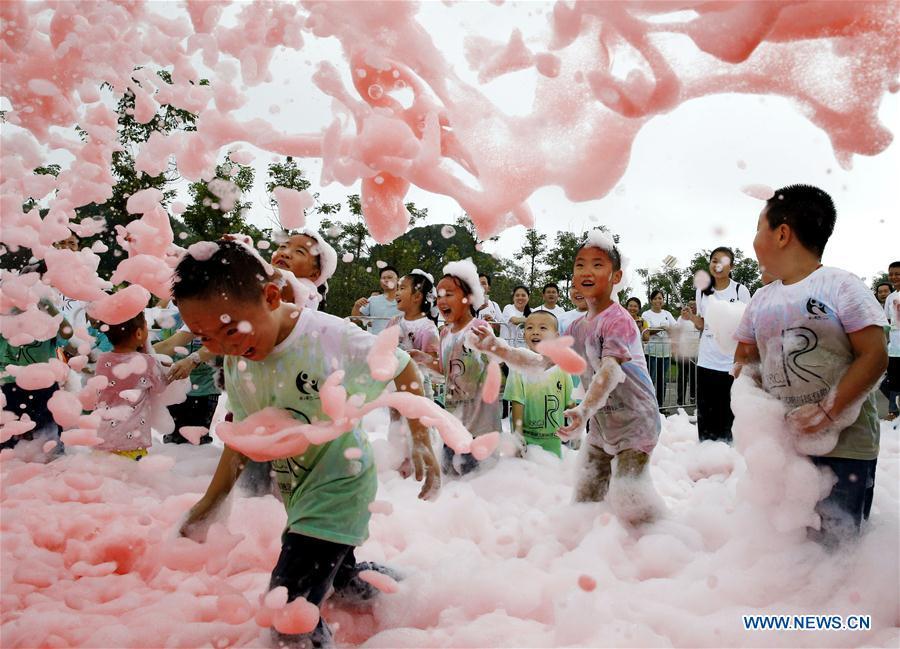 In this file photo taken on Sept. 16, 2016, children enjoy themselves in a foam activity in a tourist resort in southwest China\'s Chongqing. As China celebrates the International Children\'s Day, there arises the occasion for grown-ups to think back over the joys of childhood. With the evolution of technology and lifestyle, children are exposed to a wider range of entertainment. Nevertheless, joy would remain a childhood motif no matter how its forms change with time. (Xinhua/Zhang Yi)
