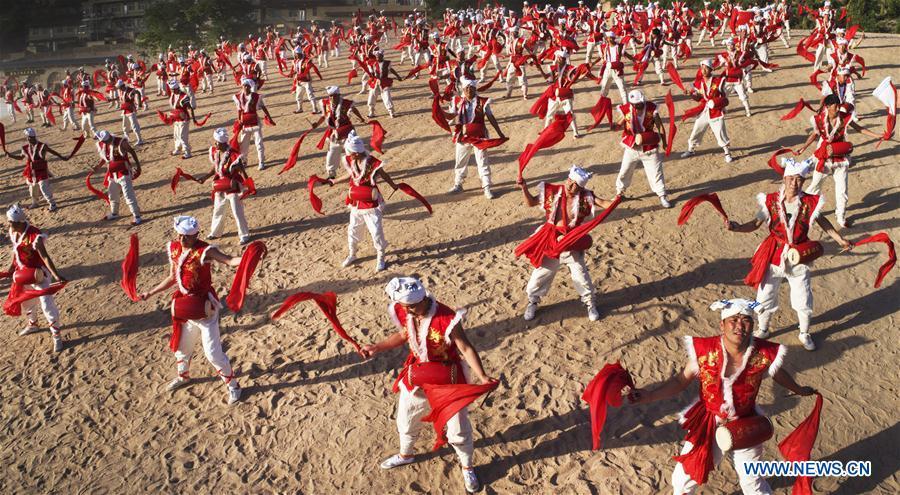 Villagers perform Ansai waist drums for tourists at Fengjiaying Village in Ansai District of Yan\'an City, northwest China\'s Shaanxi Province, May 30, 2018. It is believed that the Ansai Waist Drum dance is a unique, large-scale folk dance with a history of more than 3,000 years. Like a hurricane sweeping across the yellow earth, the dance displays the unsophisticated and wild character of peasant life on the Loess Plateau, revealing its unique artistic charm. (Xinhua/Tao Ming)