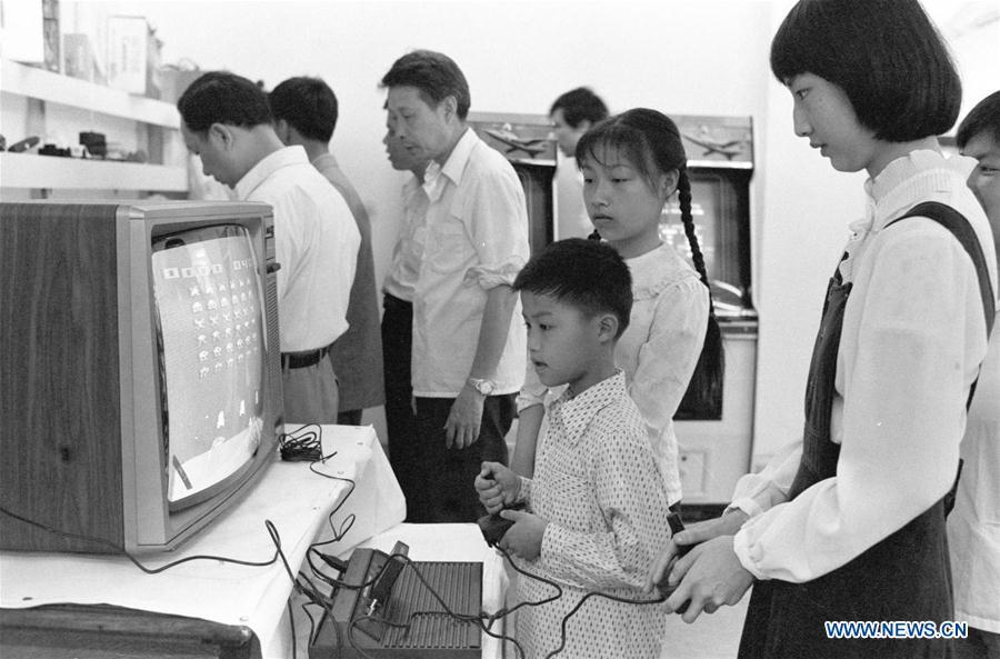 In this file photo issued on July 27, 1985, a boy tries a gaming console during a toy fair in Fuzhou, southeast China\'s Fujian Province. As China celebrates the International Children\'s Day, there arises the occasion for grown-ups to think back over the joys of childhood. With the evolution of technology and lifestyle, children are exposed to a wider range of entertainment. Nevertheless, joy would remain a childhood motif no matter how its forms change with time. (Xinhua/Huang Xingquan)