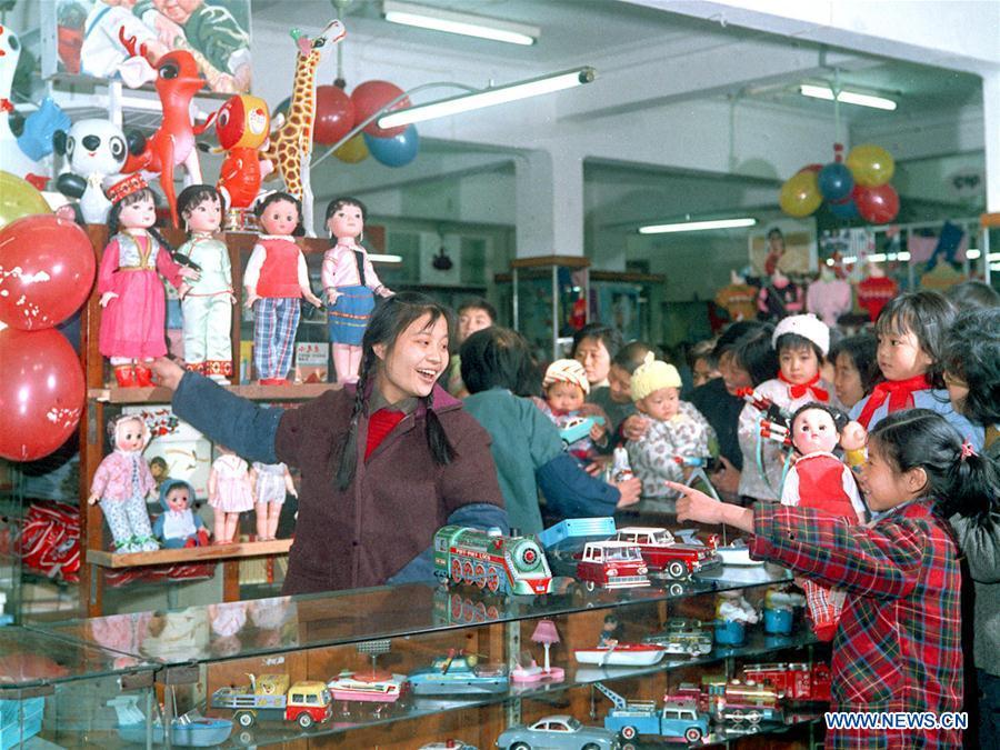 In this file photo issued on March 8, 1975, parents buy toys for their children at a shop in east China\'s Shanghai. As China celebrates the International Children\'s Day, there arises the occasion for grown-ups to think back over the joys of childhood. With the evolution of technology and lifestyle, children are exposed to a wider range of entertainment. Nevertheless, joy would remain a childhood motif no matter how its forms change with time. (Xinhua/Shen Zhengchu)