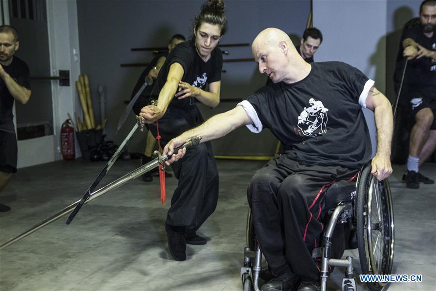Kostas Moukas (front), a disabled Wushu teacher, teaches in his wheelchair, in Athens, Greece, June 5, 2018. Kostas Moukas started practicing Wushu since 2003 and is the only Wushu teacher in a wheelchair in Greece. He trains mixed classes that include seven disabled athletes who compete officially in the national championships. (Xinhua/Panagiotis Moschandreou)