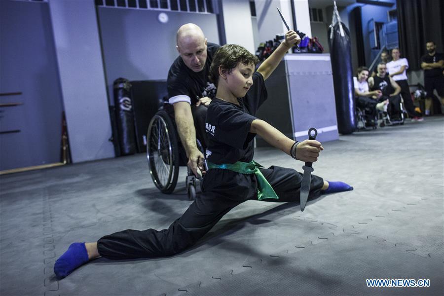 Kostas Moukas (back), a disabled Wushu teacher, teaches in his wheelchair, in Athens, Greece, June 5, 2018. Kostas Moukas started practicing Wushu since 2003 and is the only Wushu teacher in a wheelchair in Greece. He trains mixed classes that include seven disabled athletes who compete officially in the national championships. (Xinhua/Panagiotis Moschandreou)