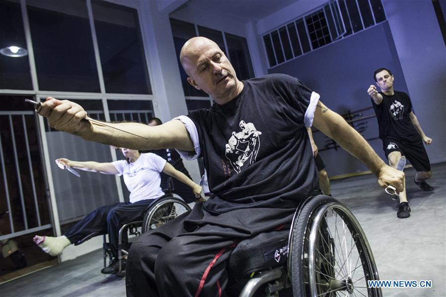 Kostas Moukas (front), a disabled Wushu teacher, teaches in his wheelchair, in Athens, Greece, June 5, 2018. Kostas Moukas started practicing Wushu since 2003 and is the only Wushu teacher in a wheelchair in Greece. He trains mixed classes that include seven disabled athletes who compete officially in the national championships. (Xinhua/Panagiotis Moschandreou)