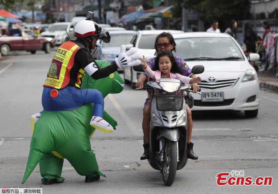 Thai police sergeant Tanit Bussabong directs traffic wearing a costume where he appears to ride a T-rex dinosaur outside a school in Nakhon Nayok on June 4, 2018. Bussabong, who has around 20 different outfits including Minnie Mouse and a bear for his traffic duty outside the kindergarten, said his prehistoric uniform is teaching kids road safety and convincing parents to obey traffic laws. (Photo/Agencies)