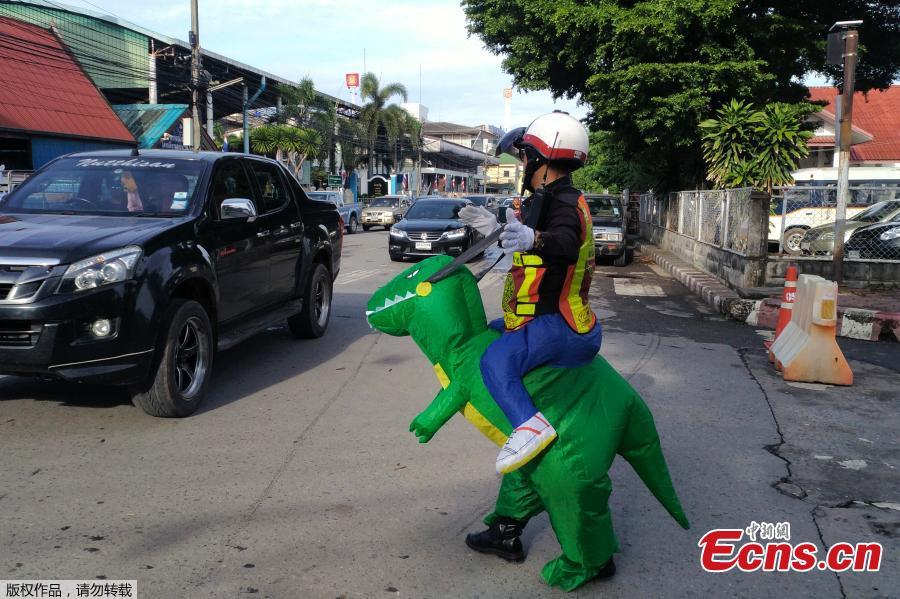 Thai police sergeant Tanit Bussabong directs traffic wearing a costume where he appears to ride a T-rex dinosaur outside a school in Nakhon Nayok on June 4, 2018. Bussabong, who has around 20 different outfits including Minnie Mouse and a bear for his traffic duty outside the kindergarten, said his prehistoric uniform is teaching kids road safety and convincing parents to obey traffic laws. (Photo/Agencies)