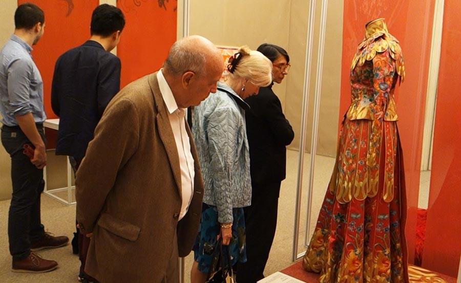 Visitors look at an embroidered dress at the Paris China Cultural Center on June 5, 2018. (Photo provided to Chinaculture.org)