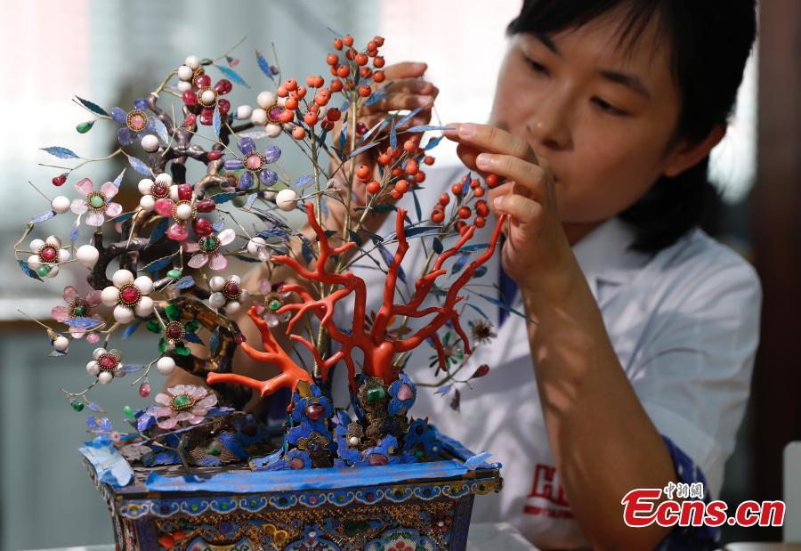 A staff member repairs a cultural relic at a restoration \'hospital\' in the Palace Museum in Beijing, June 9, 2018. As part of ongoing activities held for China\'s Cultural and Natural Heritage Day, the first batch of 40 people watched \'doctors\' repairing pieces from some of the museum\'s collections, including pieces of calligraphy, paintings, bronzeware and clocks, under the guidance of volunteers. Established in December 2016, the restoration hospital is located in the west of the Palace Museum. The facility covers 13,000 square meters and has the nation\'s most-advanced restoration studios. (Photo: China News Service/Liu Guanguan)