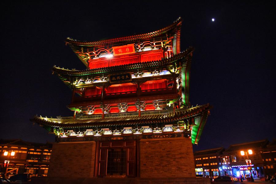 A magnificent night view of Datong Bell Tower to decorate the city. (Photo/chinadaily.com.cn)
In many historical Chinese cities, the ancient city walls stand downtown, forming a spectacular combination of the past and present — of a historical relic and a modern metropolis. Datong\'s city walls are no exception.
The ancient city wall of Datong was built in the fifth year of the Hongwu Period during the Ming Dynasty (1368-1644) by Xu Da, a senior general of the dynasty. In building it he utilized old ramparts of the previous Northern Wei, Tang, Liao, and Yuan dynasties. The Datong city wall has four sides, covering an area of 3.28 square kilometers.
If you pay a visit to the city walls in the evening, you will see great differences between day and night. Lighting on the interval towers are switched on as night falls, creating a surreal and romantic scene.
Standing on this wall, one can’t help but imagine rows of archers, guns, cannons and soldiers trying to defend the city from invaders.
In ancient times, each city\'s walls were made of different layers varying in scale and form. There were strict rules for height, width, as well as number of gates and towers depending on whether the city was the capital, a provincial capital or a county.
The study of these ancient walls has helped experts to learn more about traditional Chinese culture and history.