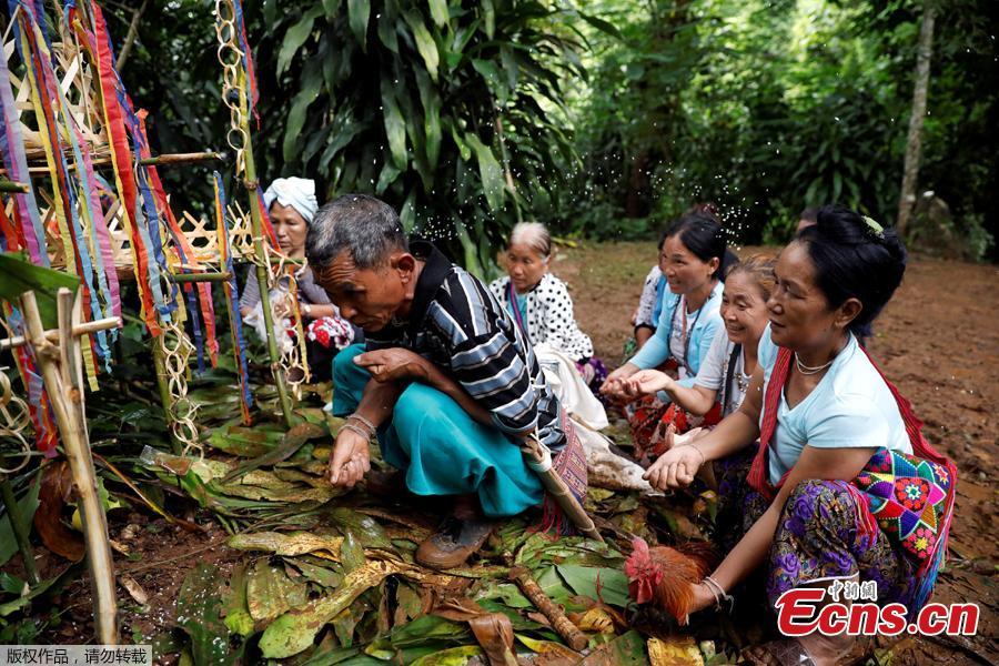 People spare rice as they pray near the Tham Luang caves during a search for members of an under-16 soccer team and their coach, in the northern province of Chiang Rai, Thailand, June 27, 2018. Twelve boys, aged 11 to 16, and their 25-year-old coach, were trapped on Saturday after heavy rain flooded the cave complex in a forest park in the northern province of Chiang Rai. (Photo/Agencies)