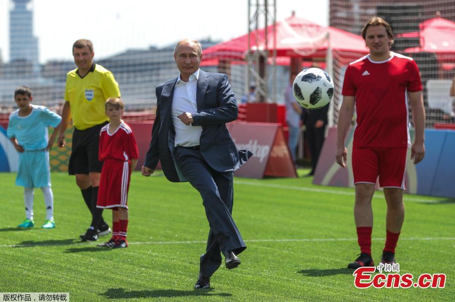Russian President Vladimir Putin kicks the ball during the opening of an exhibition match in the World Cup Football Park in Red Square in central Moscow, Russia June 28, 2018. Young Russian footballers taking part in the exhibition match had the chance to show-off their skills in front of FIFA Legends as well as Gianni Infantino and Vladimir Putin. (Photo/Agencies)