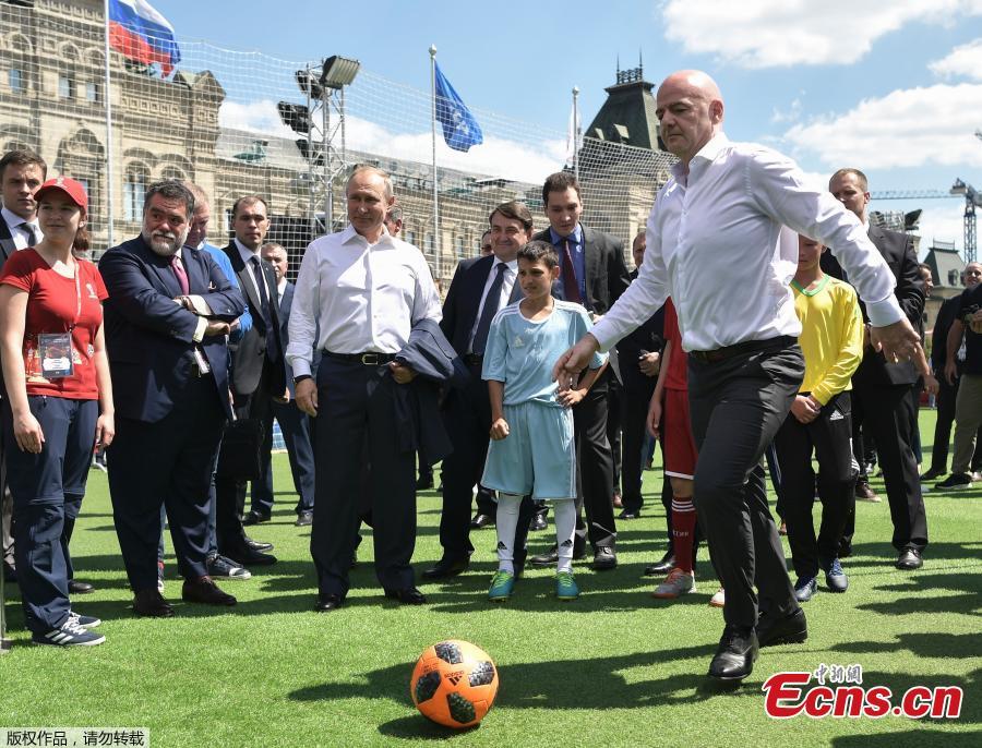 FIFA President Gianni Infantino (Right), kicks the ball as Russian President Vladimir Putin, center, looks at him during an opening friendly soccer match between two children teams and FIFA legends at a Football Park in Red Square during the 2018 soccer World Cup in the Spartak Stadium in Moscow, Russia, Thursday, June 28, 2018. (Photo/Agencies)