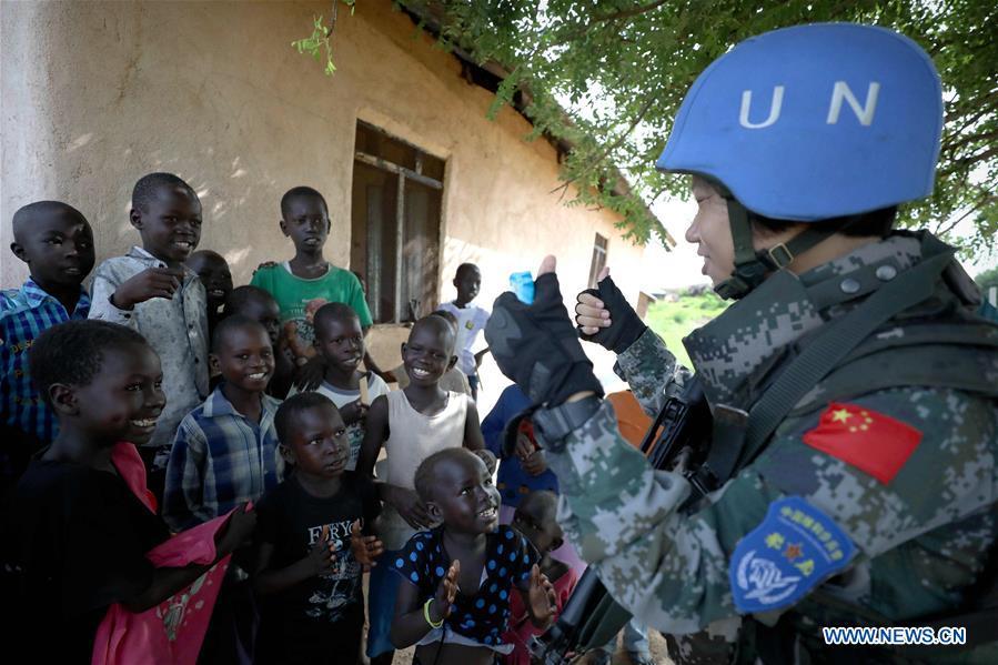 Chinese peacekeeper Yu Peijie (R) sings songs with local children in Juba, South Sudan, on April 30, 2018. Yu Peijie, 26-year-old, is the leader of the female peacekeeper unit of Chinese peacekeeping infantry batallion to South Sudan. She has a nickname called \