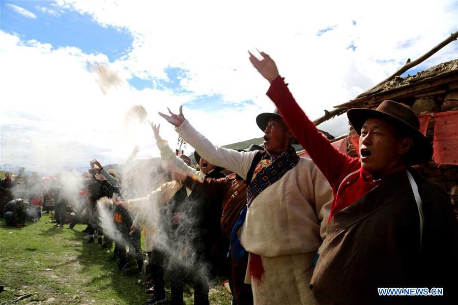 People of Tibetan ethnic group take part in a ceremony to pray for harvest during the annual Ongkor Festival in Qangkyim Village of Shannan City, southwest China\'s Tibet Autonomous Region, July 14, 2018. The Ongkor Festival, or Bumper Harvest Festival, which has a history of more than 1,500 years, is celebrated annually by local farmers praying for good harvests of crops. (Xinhua/Lhunzhub Cering)