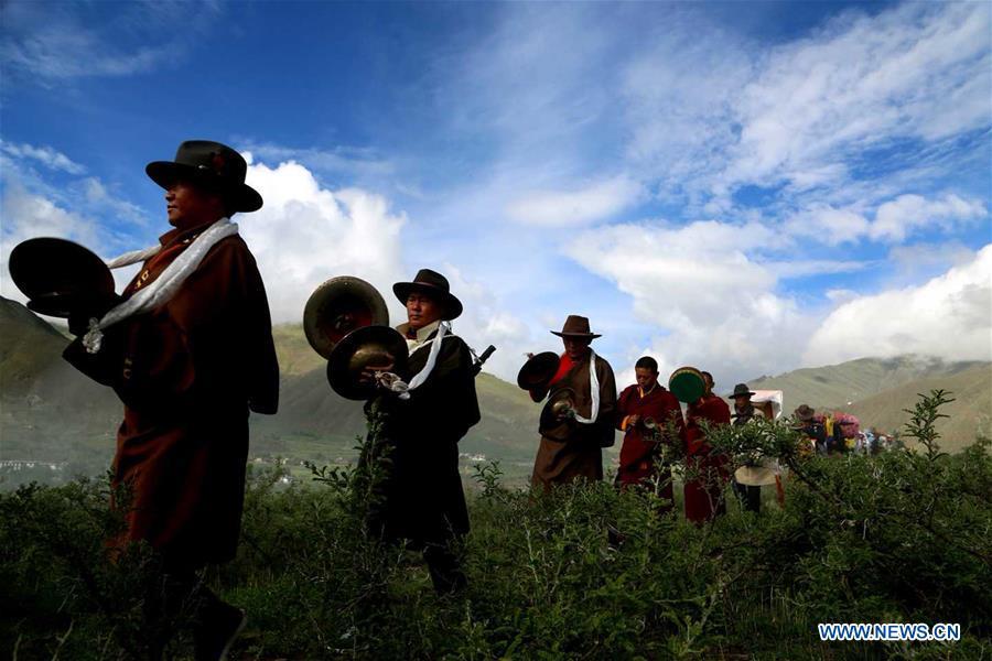 People of Tibetan ethnic group take part in a ceremony to pray for harvest during the annual Ongkor Festival in Qangkyim Village of Shannan City, southwest China\'s Tibet Autonomous Region, July 14, 2018. The Ongkor Festival, or Bumper Harvest Festival, which has a history of more than 1,500 years, is celebrated annually by local farmers praying for good harvests of crops. (Xinhua/Lhunzhub Cering)