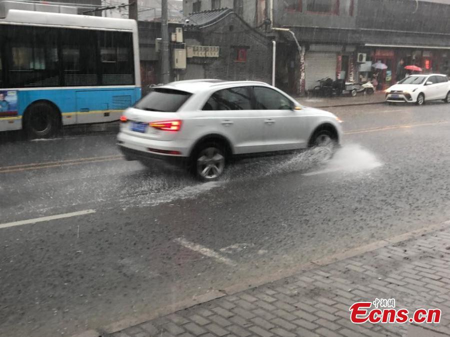 Vehicles drive during a downpour in Xicheng district of Beijing, on July 17, 2018. Areas of Beijing saw flooding after several days of rain. (Photo: China News Service/ Zhang Kaixin)
