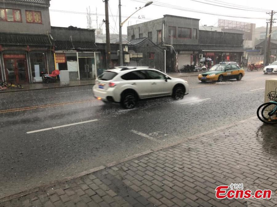 Vehicles drive during a downpour in Xicheng district of Beijing, on July 17, 2018. Areas of Beijing saw flooding after several days of rain. (Photo: China News Service/ Zhang Kaixin)