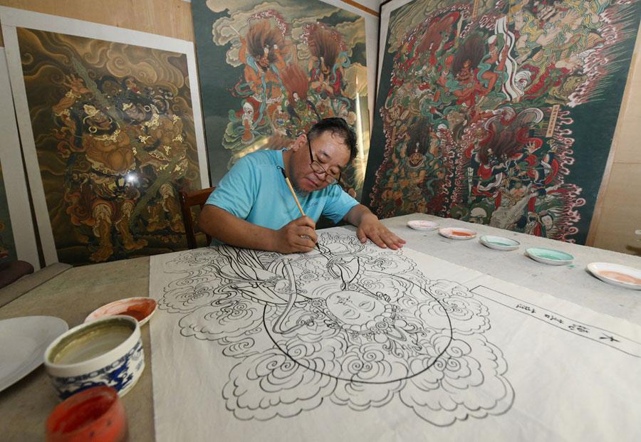 Yao Shulong creates replicas of traditional Chinese New Year paintings of Pilu Temple in his studio on July 24, 2018. (Photo/Xinhua)