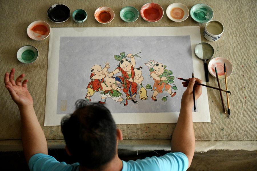Yao Shulong draws a traditional Chinese New Year painting using mural techniques in his studio on July 24, 2018. (Photo/Xinhua)
Folk painter Yao Shulong was taken by his father to Pilu Temple in North China\'s Hebei Province at age 6, and ever since then he has built a special connection with murals in the temple.
In 2006, he began to make replicas of the murals on paper. After 10 years of practicing line drawing, coloring and powdering, he has managed to make life-size replicas of the murals spanning more than 200 square meters on paper.
Through exhibitions and lecture tours in colleges over the past two years, Yao has promoted traditional murals to wider public audiences.