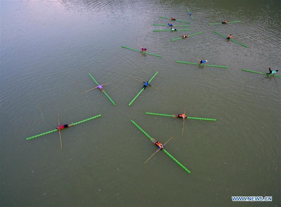 Middle school students practice single bamboo drifting on water in Rongjiang County, southwest China\'s Guizhou Province, Aug. 11, 2018. Single bamboo drifting originated in China\'s Guizhou and requires a person to stand or sit on a single piece of bamboo while performing graceful movements. (Xinhua/Wang Bingzhen)