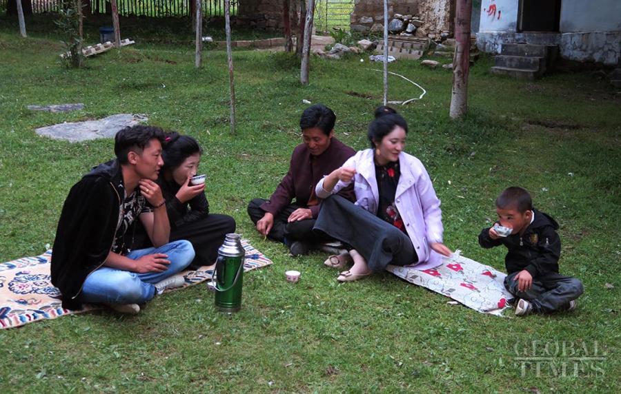 Locals enjoy the yogurt while sitting on blankets in a field during the Shoton Festival. (Photo: Li Hao/GT)