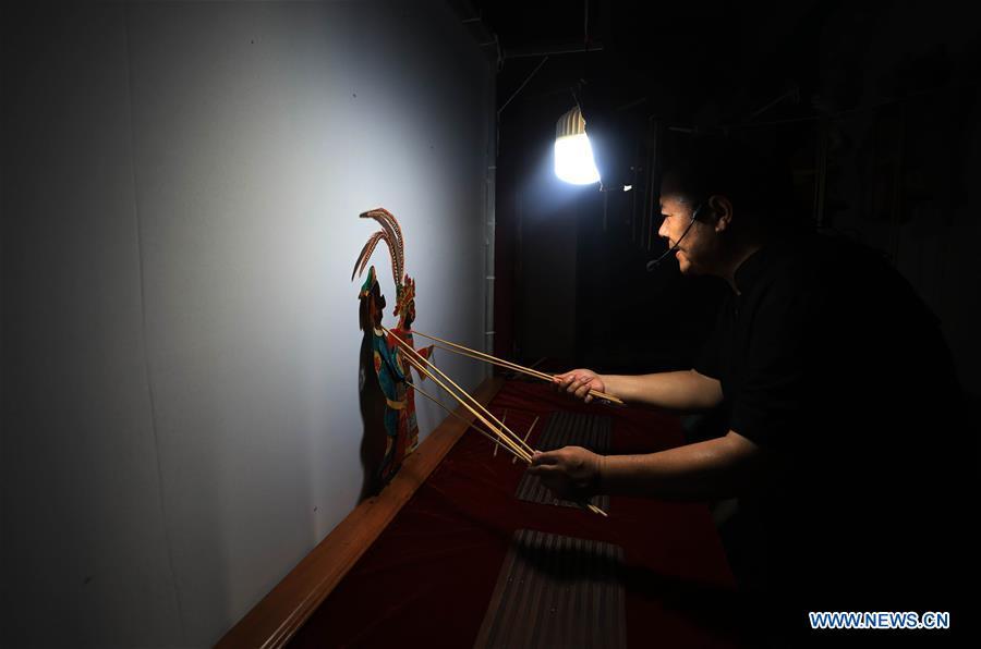 Li Wei performs a shadow puppet show in Jinan, east China\'s Shandong Province, July 15, 2018. Li, 63, is the son of Jinan shadow puppet show master Li Xingtang. He learned shadow puppet performance from his father in childhood. After his father passed away 11 years ago, Li Wei took over the task of developing and innovating the art of Jinan puppet show. Since last summer, Li has kept on presenting traditional shadow puppet plays at the Baihuazhou scenic area in Jinan every weekend for free. (Xinhua/Zhao Xiaoming)