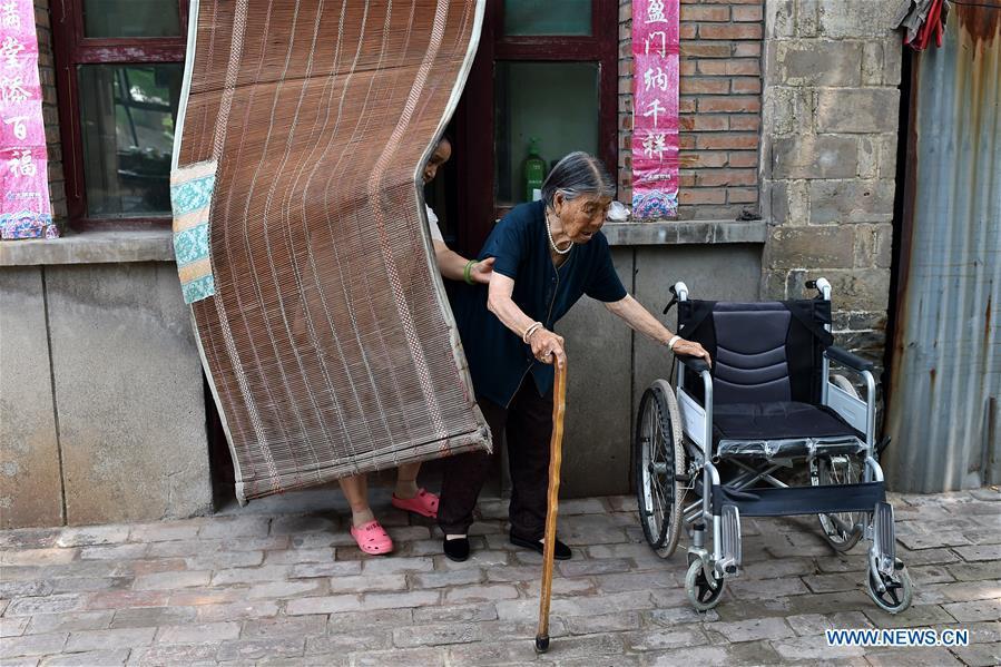 90-year-old Hao Yuelian (R) walks to a courtyard with the assistance of her daughter in Yanggongling Village of Wuxiang County, north China\'s Shanxi Province, July 24, 2018. In June of 1943, Hao was abducted by Japanese invaders. One month later, her family redeemed her from the Japanese army. After that, she was captured again and rescued by her father and brother. Women forced into sexual slavery by the Imperial Japanese Army before and during World War II were called \