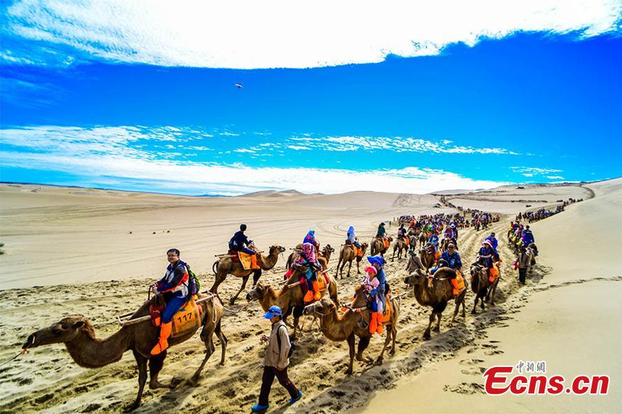 Tourists visit the Mingsha Hill scenic spot in the Gobi desert in Dunhuang City, Northwest China\'s Gansu Province, Aug. 15, 2018. Consisting of a group of sand dunes, the Mingsha Hill, or \