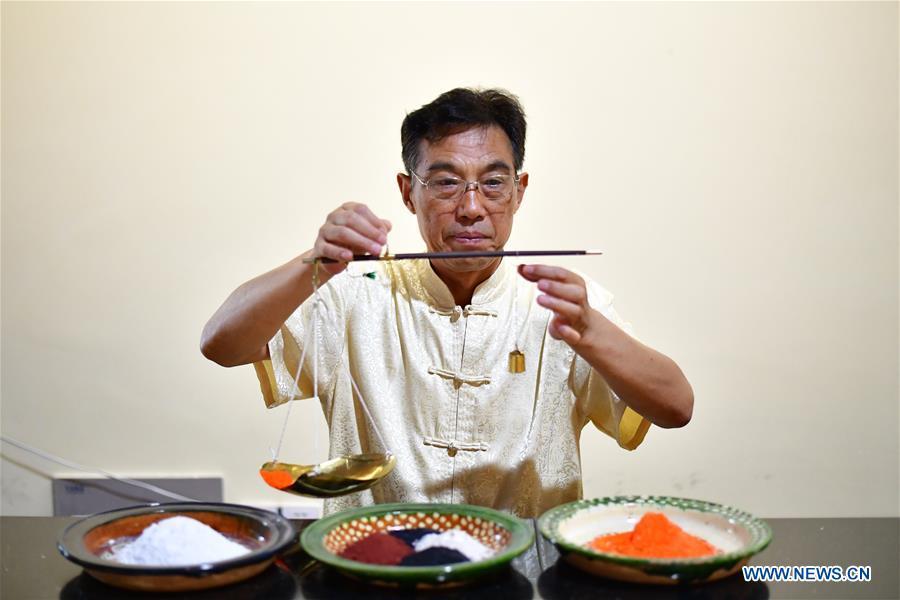 Tri-colored glazed pottery technique inheritor Gao Shuiwang makes glaze for potteries in Nanshishan Village, Mengjin County, Luoyang City, central China\'s Henan Province, Aug. 15, 2018. Gao is a leading figure in the revival of tri-colored glazed pottery, or Sancai, a Chinese porcelain characterized by a glaze with three intermingled colours. The producing technique of Sancai, which flourished in the Tang Dynasty (618-907 AD), was very complex and listed as one of China\'s National Intangible Heritages in 2008. Nanshishan Village in Henan is regarded as an important village of Sancai culture, with more than 70 enterprises now engaging in the industry. (Xinhua/Feng Dapeng)